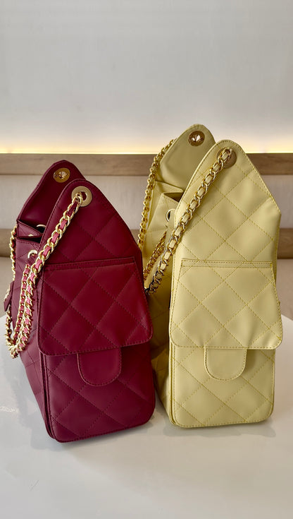 Bolso Charlotte vista lateral mostrando bolsillos cargo y correa de cadena estilo Chanel 25